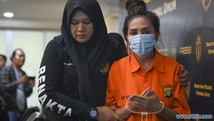 Petugas menggiring tersangka saat konferensi pers kasus praktik kecantikan ilegal di Polda Metro Jaya, Jakarta, Jumat (6/12/2024). Subdit Renakta Ditreskrimum Polda Metro Jaya berhasil membongkar praktik klinik kecantikan ilegal dan produksi alat kesehatan tidak sesuai standar serta menangkap dua tersangka yang menawarkan layanan penghilang bopeng wajah menggunakan alat bernama GTS Roller. ANTARA FOTO/Muhammad Ramdan/nym.